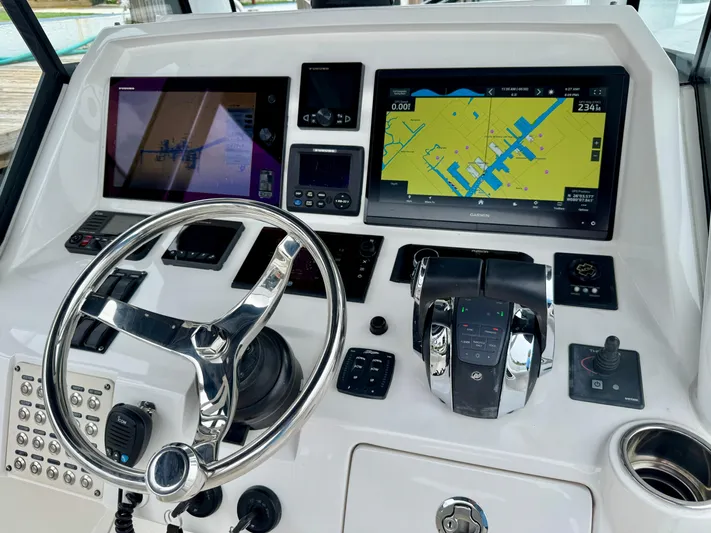  Yacht Photos Pics Control panel of a 2018 Intrepid 327 Center Console boat with navigation screens and steering wheel.