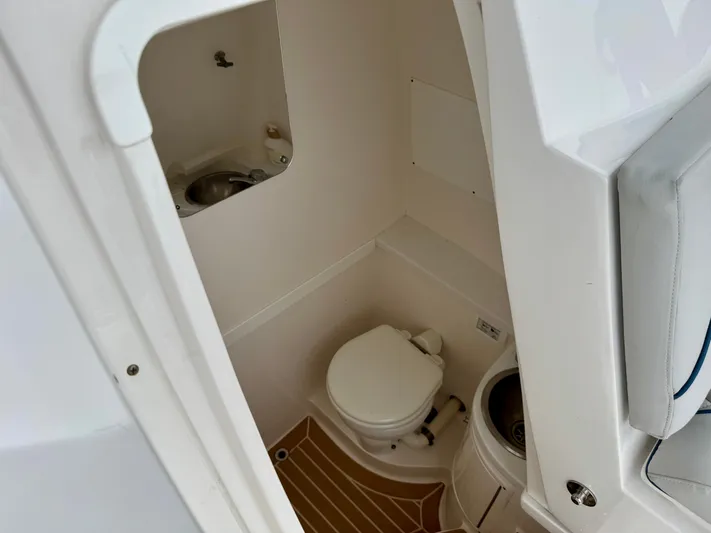  Yacht Photos Pics 2018 Intrepid 327 Center Console boat interior with compact bathroom and sink.