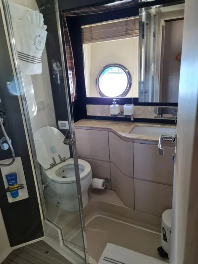 Mi Bluu Yacht Photos Pics Bathroom interior of 2019 Azimut Flybridge 66 yacht with modern fixtures and porthole window.