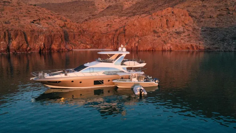 Mi Bluu Yacht Photos Pics 2019 Azimut Flybridge 66 yacht anchored in serene waters with rocky backdrop.