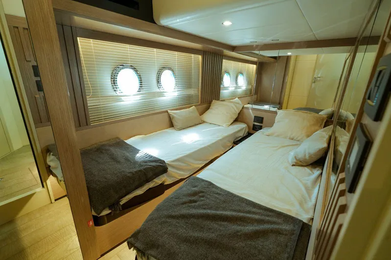  Yacht Photos Pics Luxurious cabin interior of 2024 Absolute NAVETTA 52 yacht with twin beds and porthole windows.