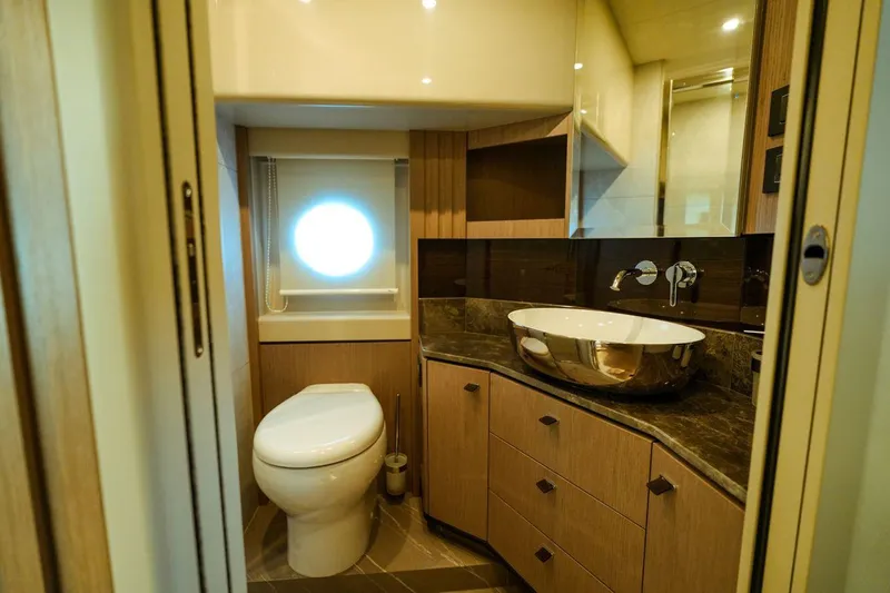  Yacht Photos Pics Luxurious bathroom in 2024 Absolute NAVETTA 52 yacht with modern fixtures and porthole window.