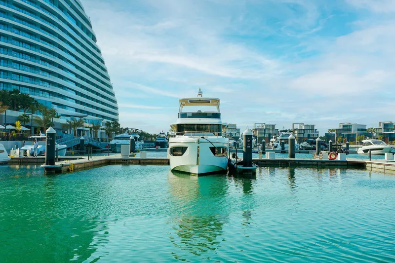  Yacht Photos Pics 2024 Absolute NAVETTA 52 yacht docked in a modern marina with clear blue skies.