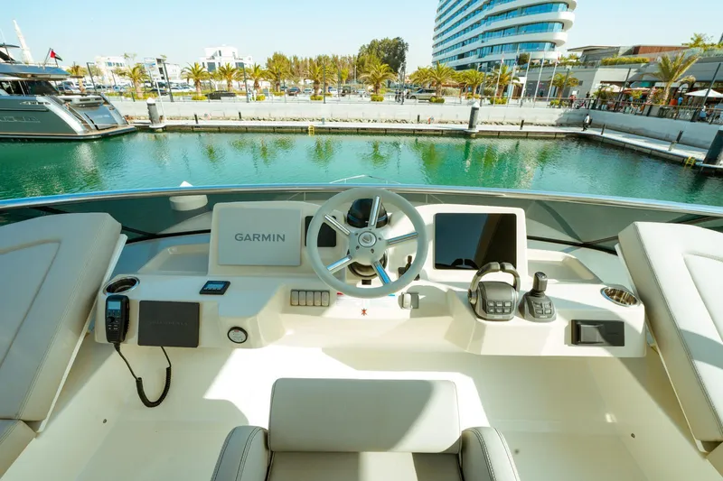 Yacht Photos Pics 2024 Absolute NAVETTA 52 yacht helm with Garmin navigation, docked in a scenic marina.
