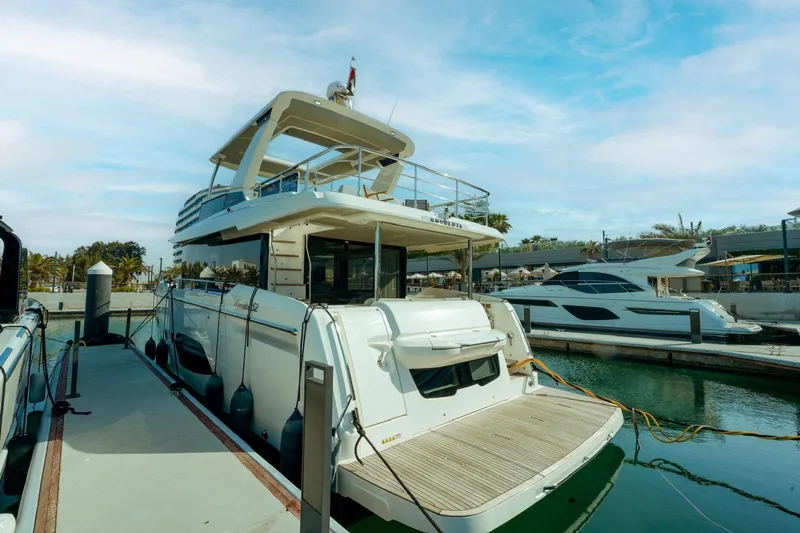  Yacht Photos Pics 2024 Absolute NAVETTA 52 yacht docked at marina under blue sky.