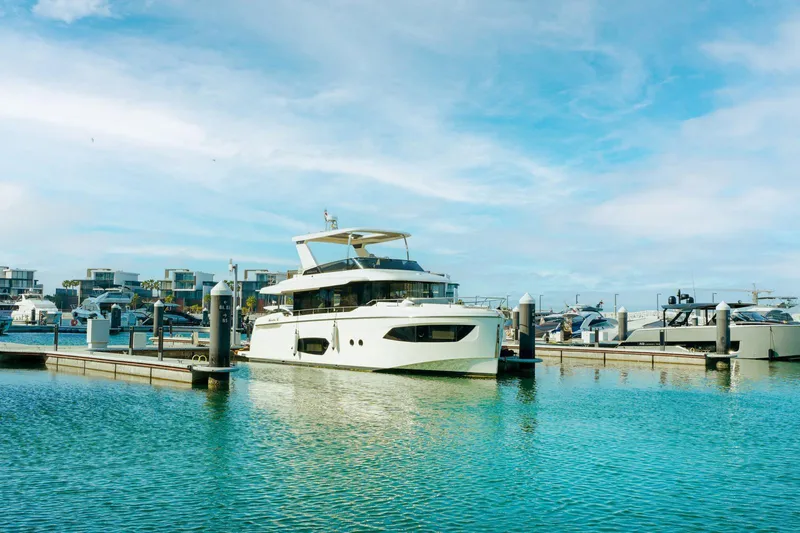  Yacht Photos Pics 2024 Absolute NAVETTA 52 yacht docked in a marina under a clear blue sky.