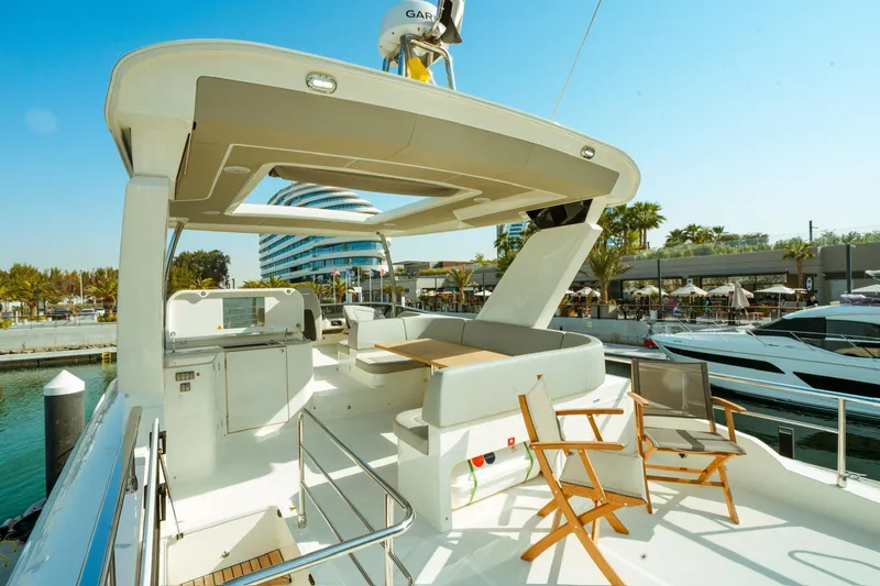  Yacht Photos Pics Luxurious 2024 Absolute NAVETTA 52 yacht deck with seating, docked at a marina.