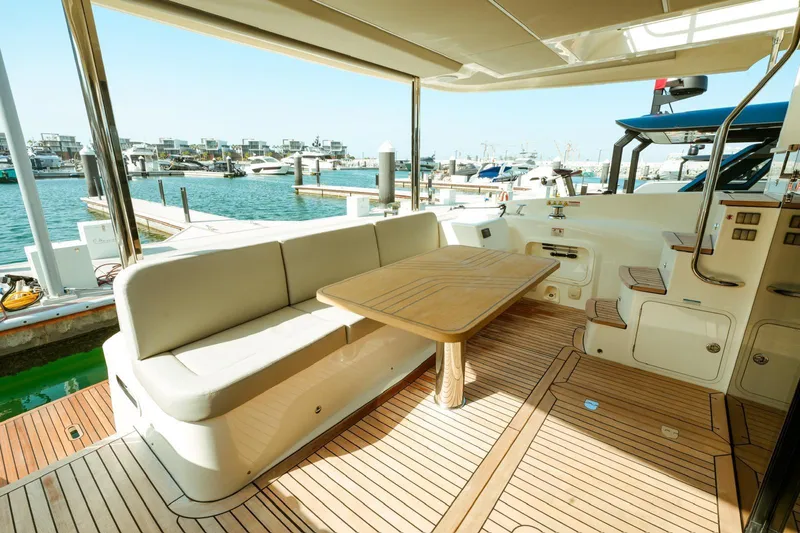  Yacht Photos Pics Luxurious 2024 Absolute NAVETTA 52 yacht deck with seating and table, docked at marina.
