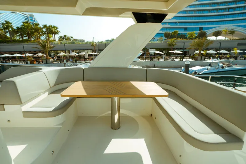  Yacht Photos Pics Luxurious seating area on 2024 Absolute NAVETTA 52 yacht with elegant wooden table.