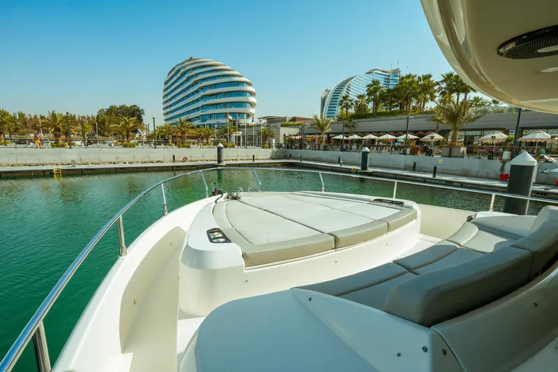  Yacht Photos Pics 2024 Absolute NAVETTA 52 yacht docked in a modern marina with futuristic buildings.