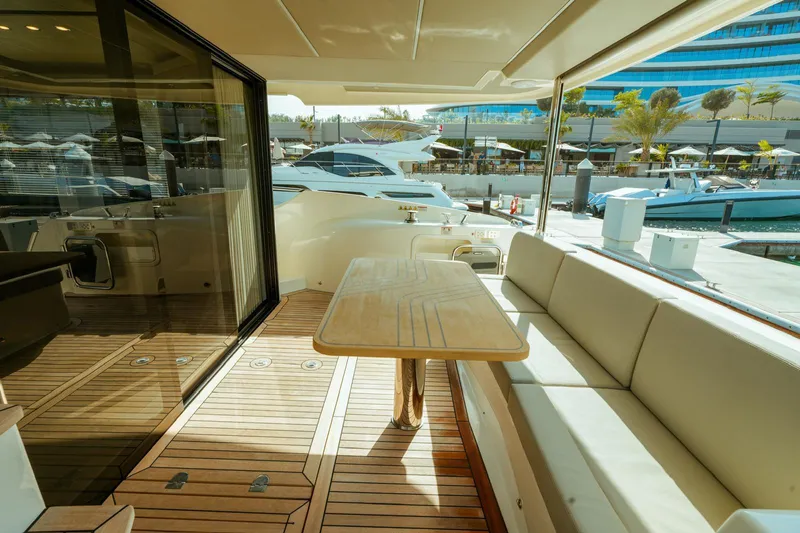  Yacht Photos Pics Luxurious 2024 Absolute NAVETTA 52 yacht deck with seating and table, docked at marina.