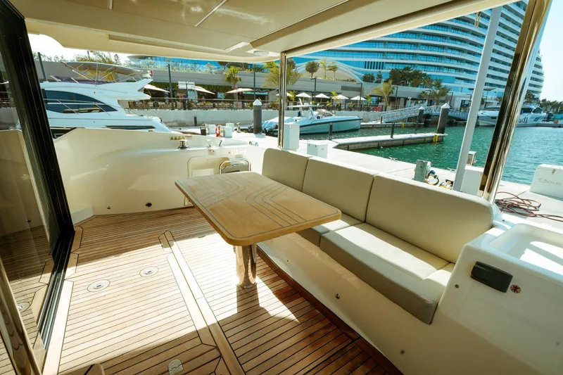  Yacht Photos Pics Luxurious 2024 Absolute NAVETTA 52 yacht deck with seating and table, docked at marina.