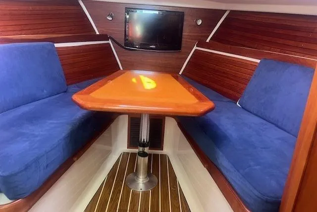  Yacht Photos Pics 2008 Back Cove 29 interior with blue seating, wooden table, and wall-mounted TV.