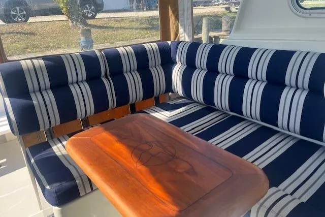  Yacht Photos Pics 2008 Back Cove 29 interior with striped seating and wooden table.