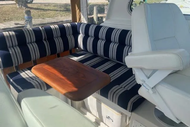  Yacht Photos Pics 2008 Back Cove 29 interior with striped seating and wooden table.