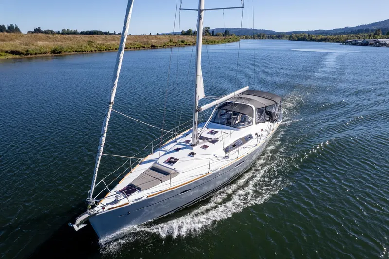Resiliance Yacht Photos Pics 2013 Beneteau Oceanis 50 sailing on a serene river under clear skies.