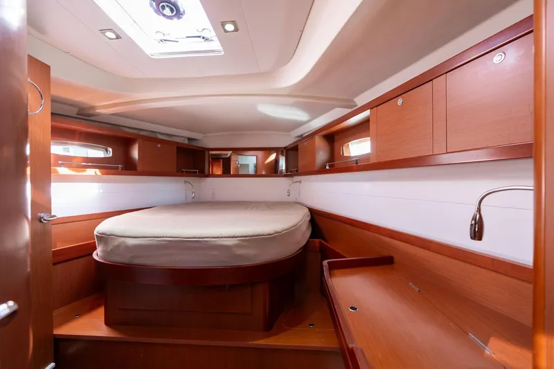 Resiliance Yacht Photos Pics Interior cabin of 2013 Beneteau Oceanis 50 yacht, featuring wood finish and cozy bed.