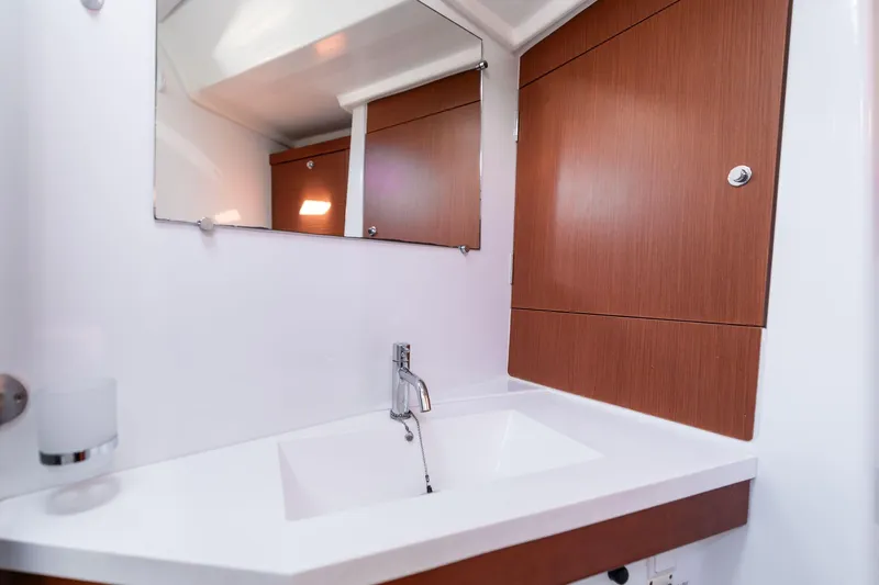 Resiliance Yacht Photos Pics Modern bathroom interior on 2013 Beneteau Oceanis 50 yacht, featuring sleek sink and wooden cabinetry.