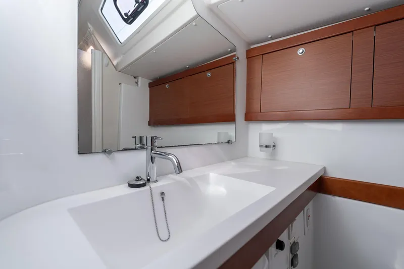 Resiliance Yacht Photos Pics Modern bathroom interior of 2013 Beneteau Oceanis 50 yacht with sleek sink and wooden cabinets.