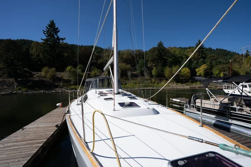Resiliance Yacht Photos Pics 2013 Beneteau Oceanis 50 sailboat docked, surrounded by lush greenery and calm waters.