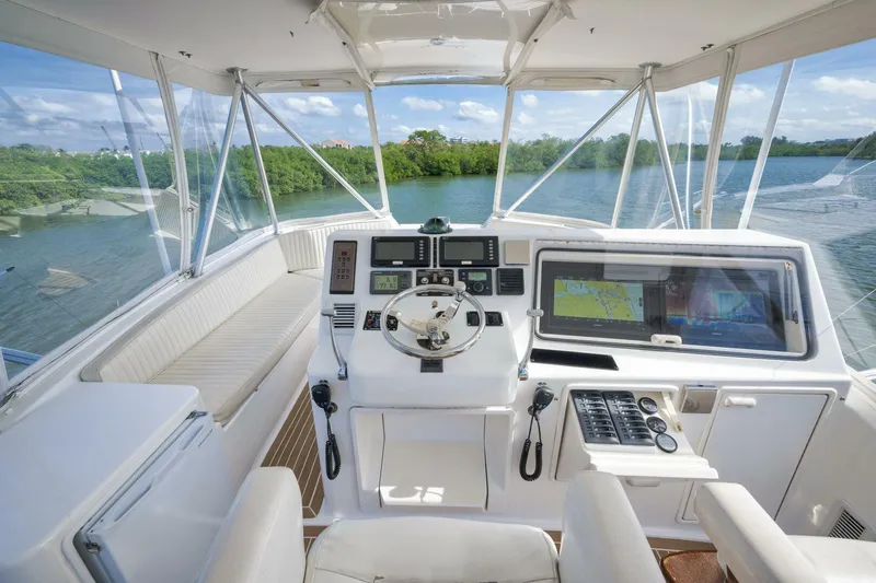 Mullet Yacht Photos Pics 2006 Ocean Yachts 50 Super Sport helm with navigation equipment, overlooking serene waters and lush greenery.