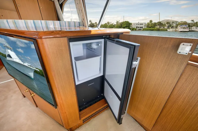 Mullet Yacht Photos Pics Open mini fridge inside 2006 Ocean Yachts 50 Super Sport, with wooden cabinetry and water view.