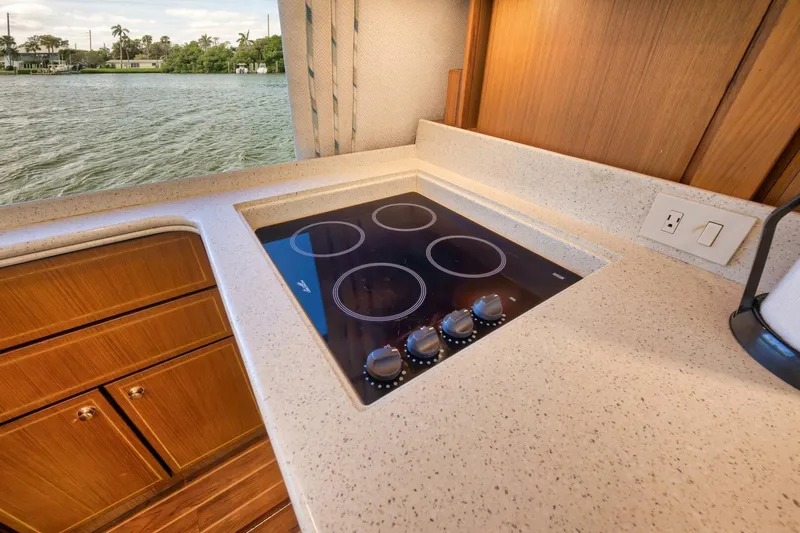 Mullet Yacht Photos Pics Modern kitchen on 2006 Ocean Yachts 50 Super Sport with electric stovetop and wooden cabinetry.