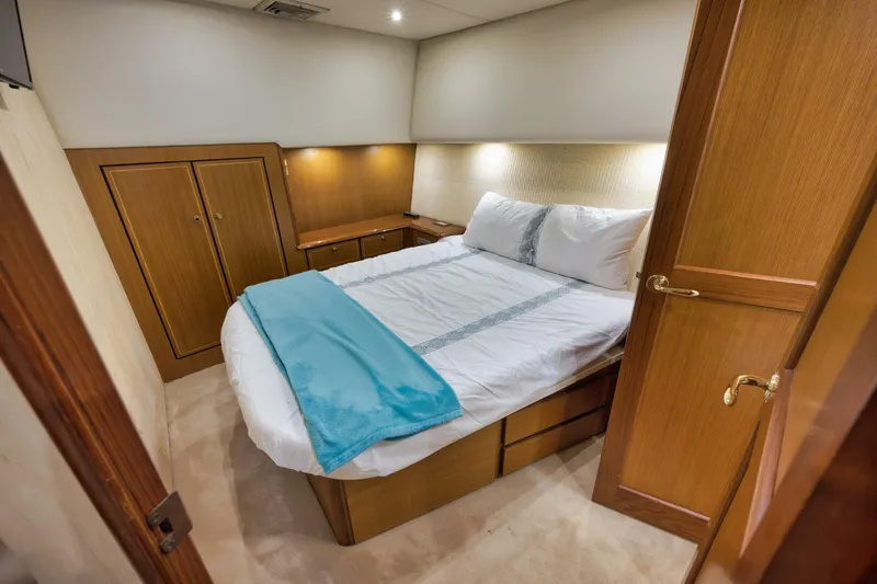 Mullet Yacht Photos Pics Luxurious bedroom interior of 2006 Ocean Yachts 50 Super Sport with cozy bed and wooden cabinetry.