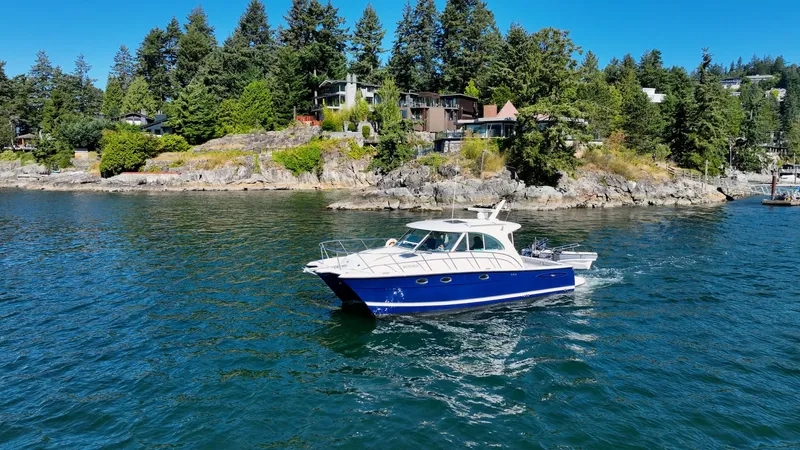  Yacht Photos Pics 2007 Glacier Bay 3480 Ocean Runner cruising near a scenic, forested shoreline.