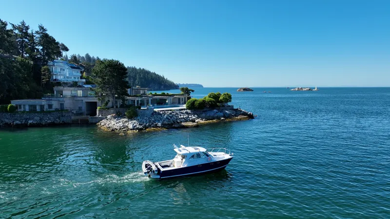  Yacht Photos Pics 2007 Glacier Bay 3480 Ocean Runner cruising near coastal homes and scenic shoreline.