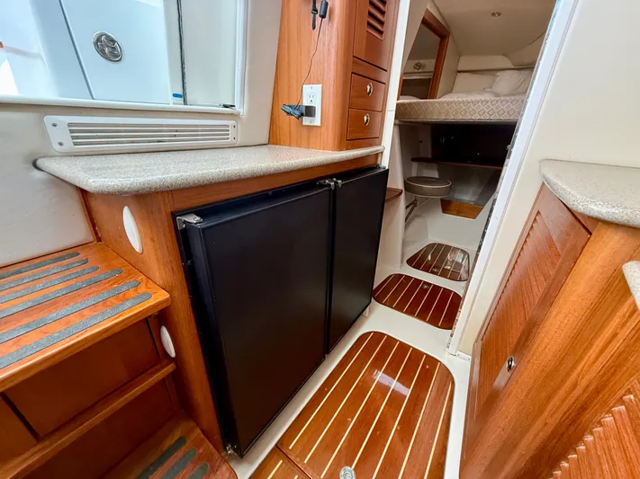  Yacht Photos Pics 2007 Glacier Bay 3480 Ocean Runner interior with wood accents and compact fridge.