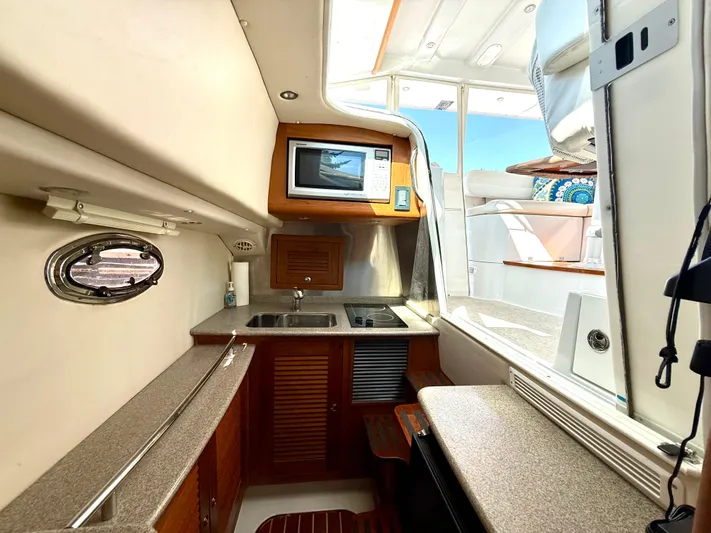  Yacht Photos Pics 2007 Glacier Bay 3480 Ocean Runner interior with kitchenette, microwave, and seating area.
