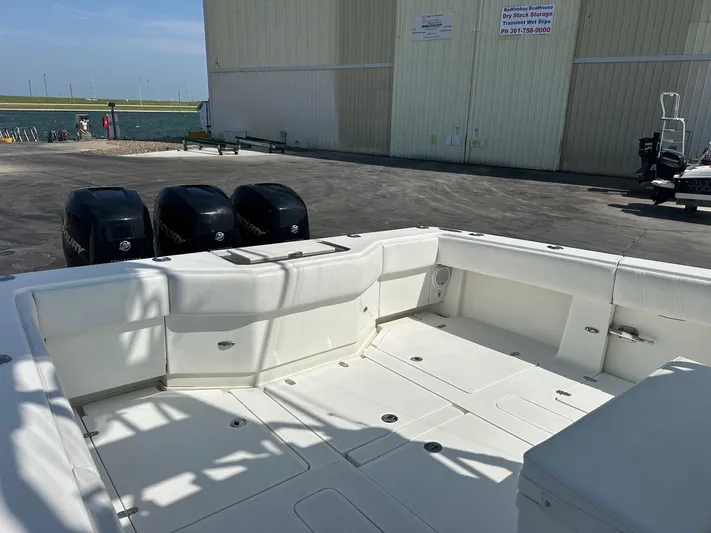  Yacht Photos Pics 2013 SeaVee 390B boat with triple outboard engines, docked near a waterfront building.