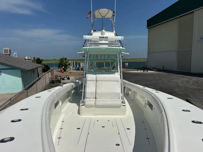  Yacht Photos Pics 2013 SeaVee 390B boat docked, featuring spacious deck and helm, with clear skies above.