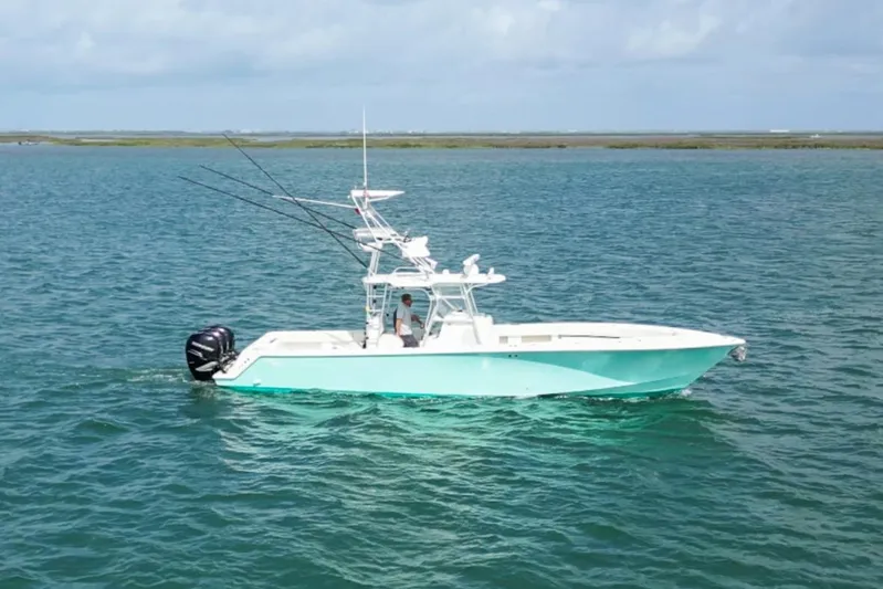  Yacht Photos Pics 2013 SeaVee 390B boat on calm blue water, equipped with fishing rods.