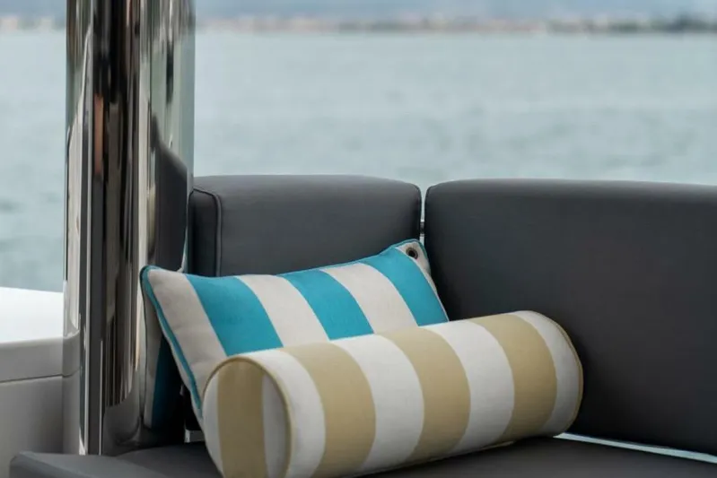 My Marina Yacht Photos Pics Cushioned seating on 2020 Bali 4.8 yacht with striped pillows, ocean view.