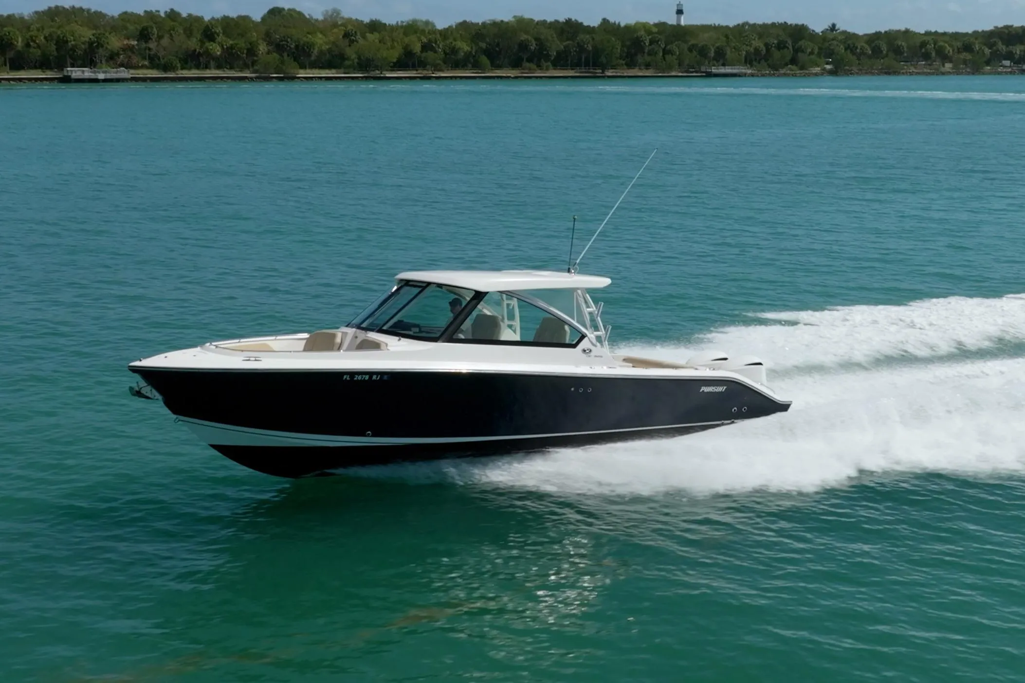 2017 Pursuit DC 325 Dual Console boat cruising on clear blue water.