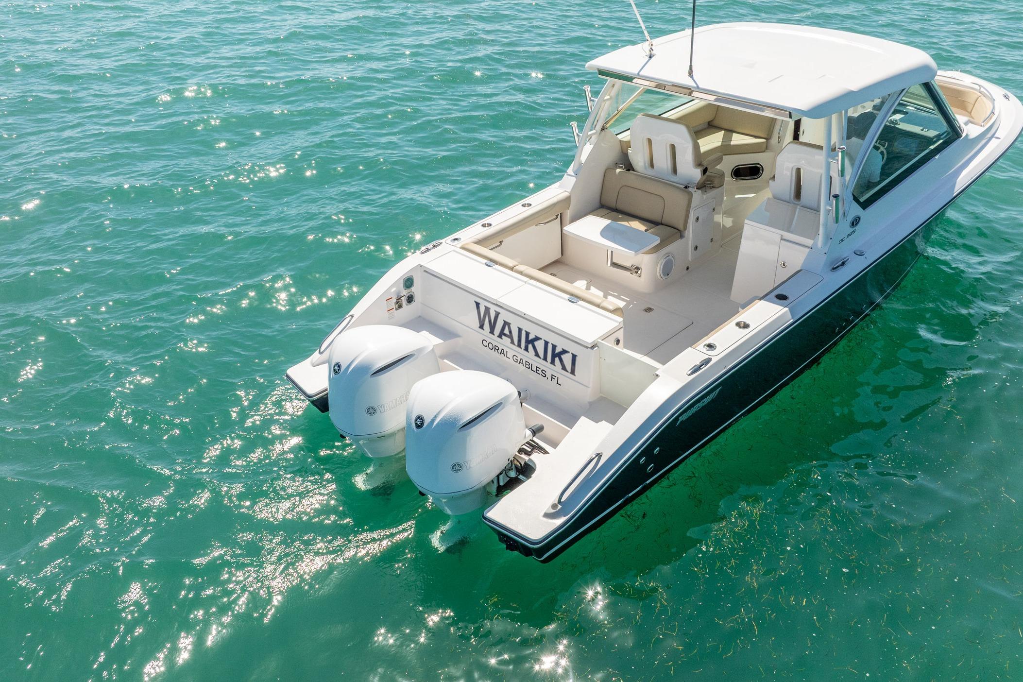 2017 Pursuit DC 325 Dual Console boat on clear turquoise water.