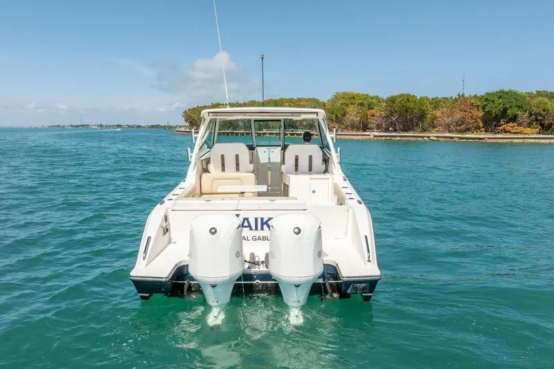 Waikiki Yacht Photos Pics 2017 Pursuit DC 325 Dual Console boat on clear blue water, rear view.