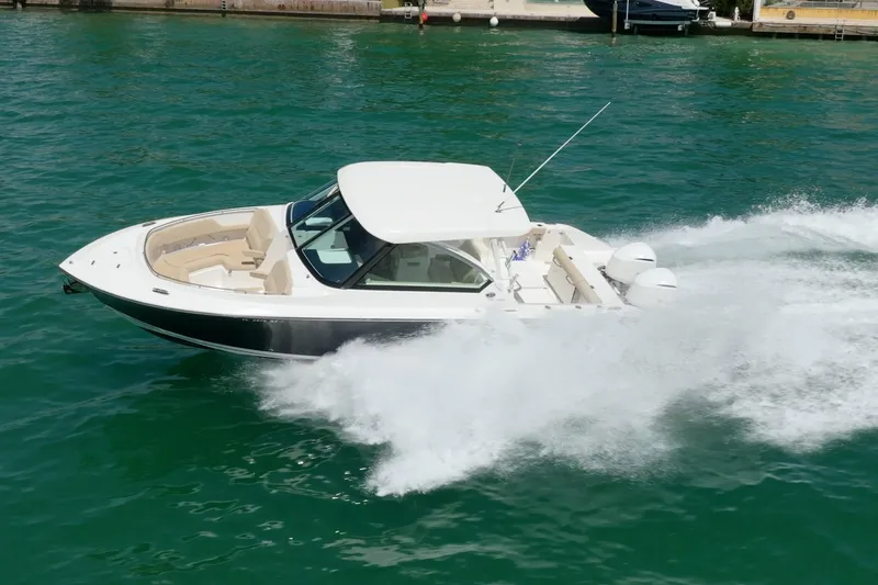 Waikiki Yacht Photos Pics 2017 Pursuit DC 325 Dual Console boat speeding on water, showcasing sleek design and powerful performance.