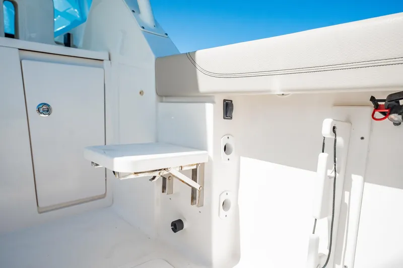 Waikiki Yacht Photos Pics 2017 Pursuit DC 325 Dual Console boat interior with foldable seat and storage compartment.