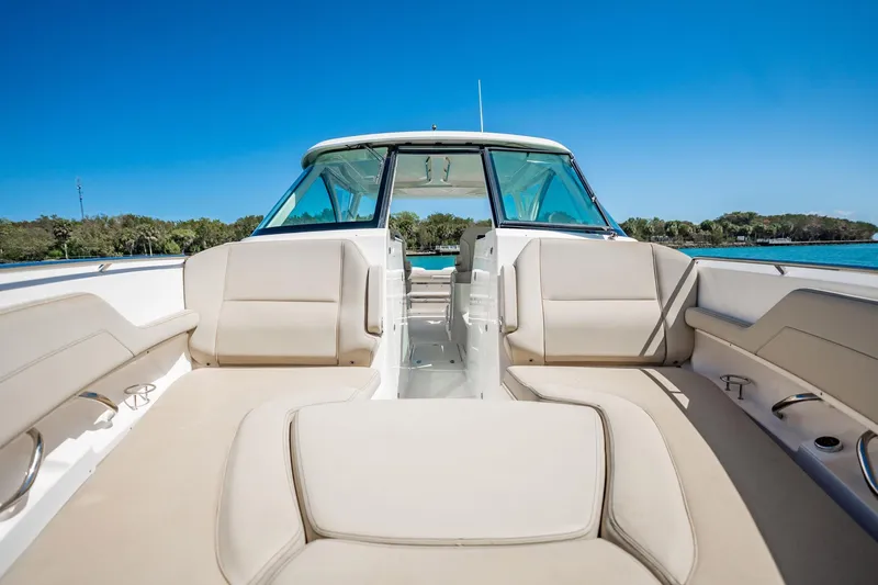 Waikiki Yacht Photos Pics 2017 Pursuit DC 325 Dual Console boat interior with beige seating and clear blue sky.