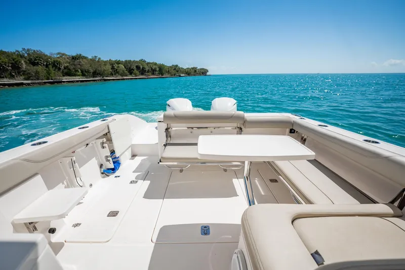 Waikiki Yacht Photos Pics 2017 Pursuit DC 325 Dual Console boat interior with seating and table, cruising on blue water.