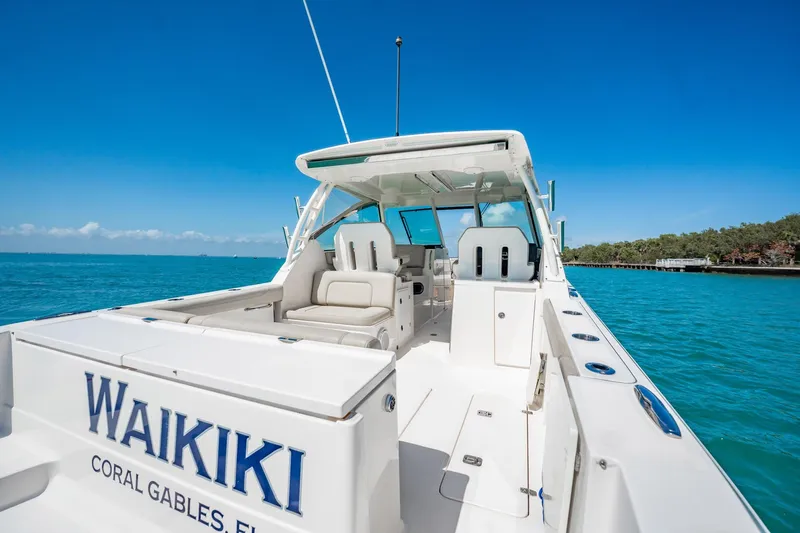 Waikiki Yacht Photos Pics 2017 Pursuit DC 325 Dual Console boat on turquoise water, labeled "Waikiki," Coral Gables, Florida.