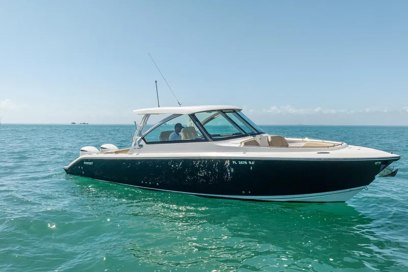 Waikiki Yacht Photos Pics 2017 Pursuit DC 325 Dual Console boat cruising on clear blue water.