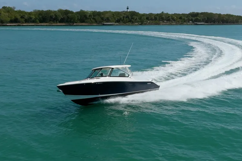 Waikiki Yacht Photos Pics 2017 Pursuit DC 325 Dual Console cruising on clear blue water.