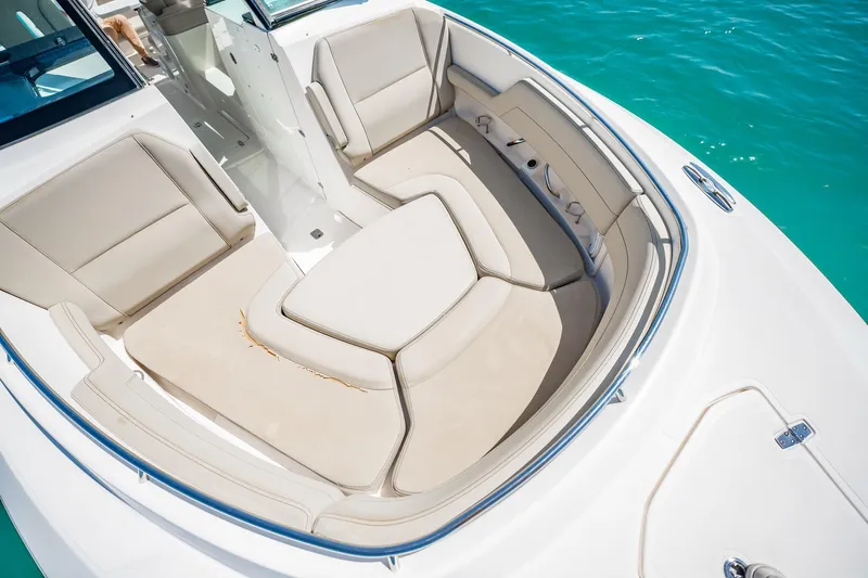 Waikiki Yacht Photos Pics 2017 Pursuit DC 325 Dual Console boat interior with beige seating, on clear blue water.