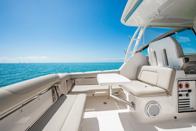 Waikiki Yacht Photos Pics 2017 Pursuit DC 325 Dual Console boat interior with ocean view, featuring comfortable seating and table.