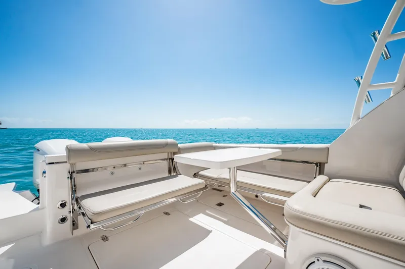 Waikiki Yacht Photos Pics 2017 Pursuit DC 325 Dual Console boat interior with ocean view, featuring seating and table.