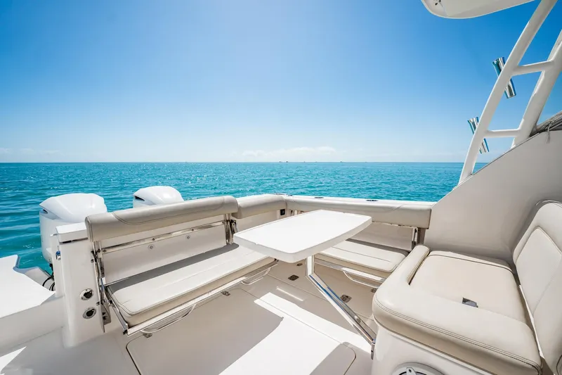 Waikiki Yacht Photos Pics 2017 Pursuit DC 325 Dual Console boat interior with ocean view, featuring comfortable seating and table.